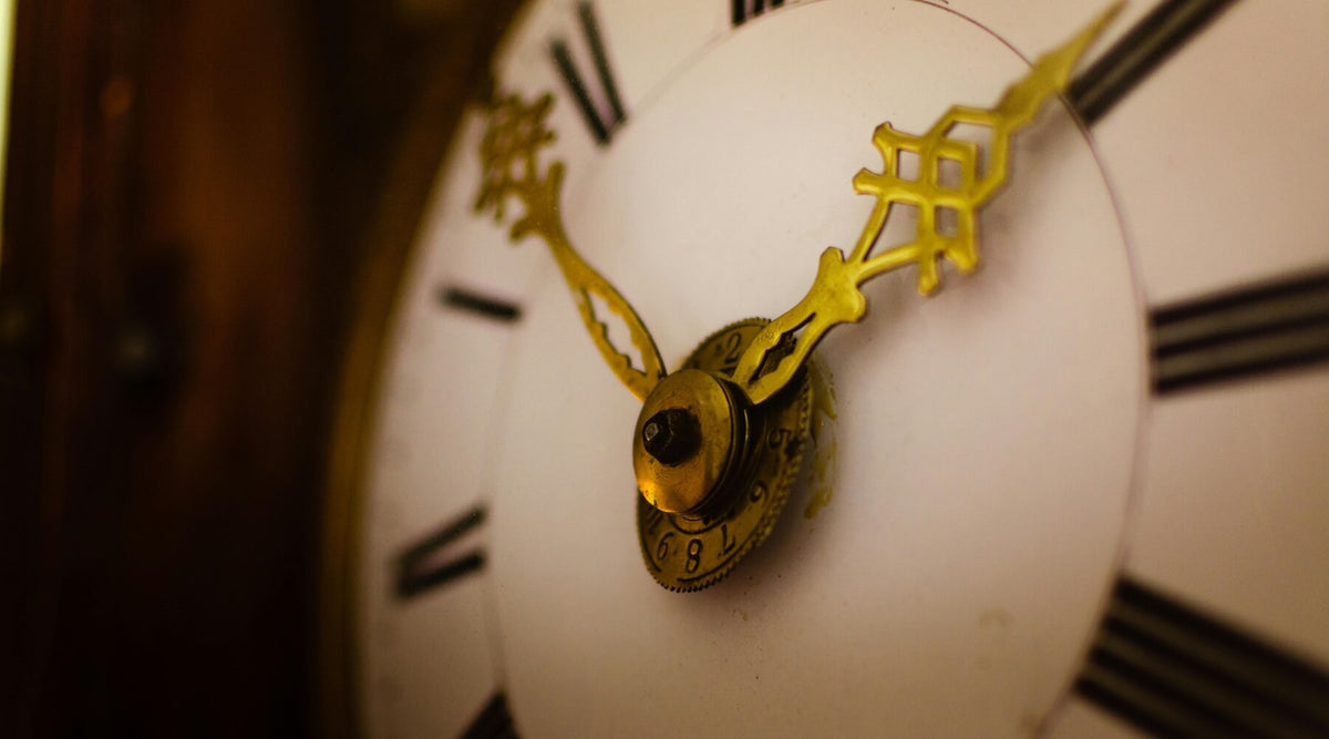 A close-up of an antique clock face with Roman numerals, subtly hinting at how Daylight Saving Time affects indoor cats