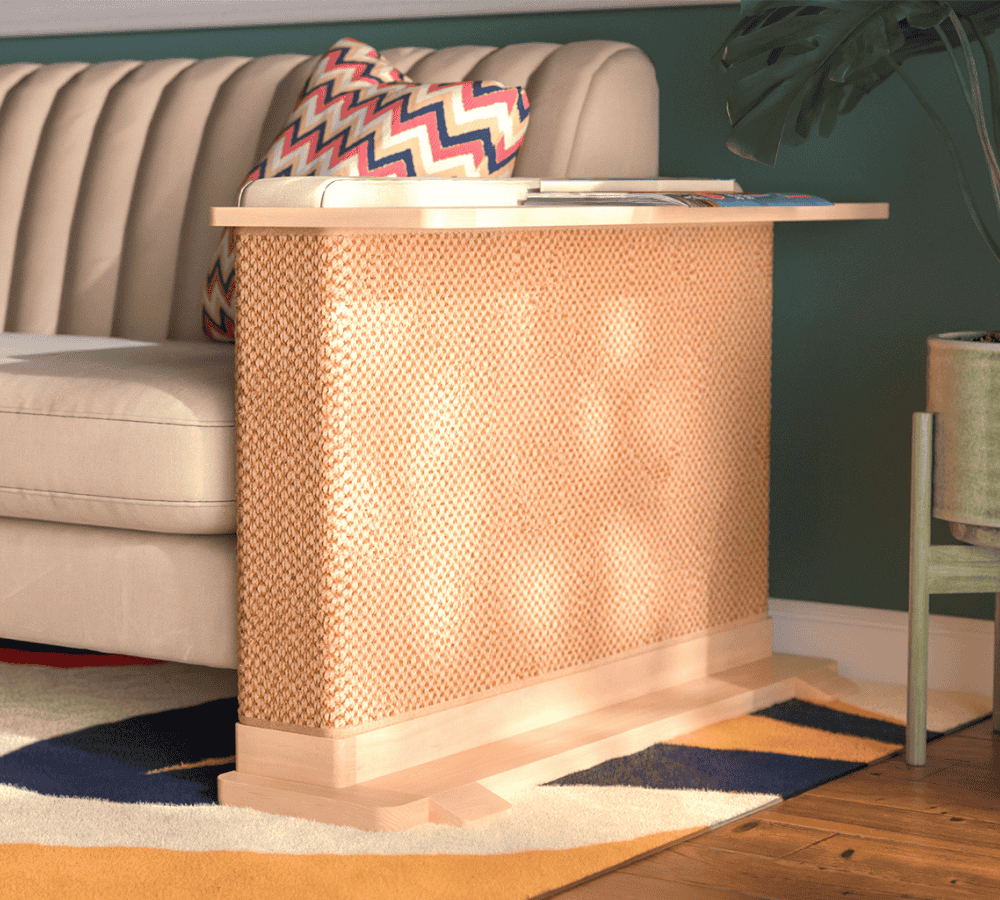 A Cat-e-Corner table placed next to a sofa, integrating a cat's scratching post with a small table, in a room with a plant and a colorful cushion.