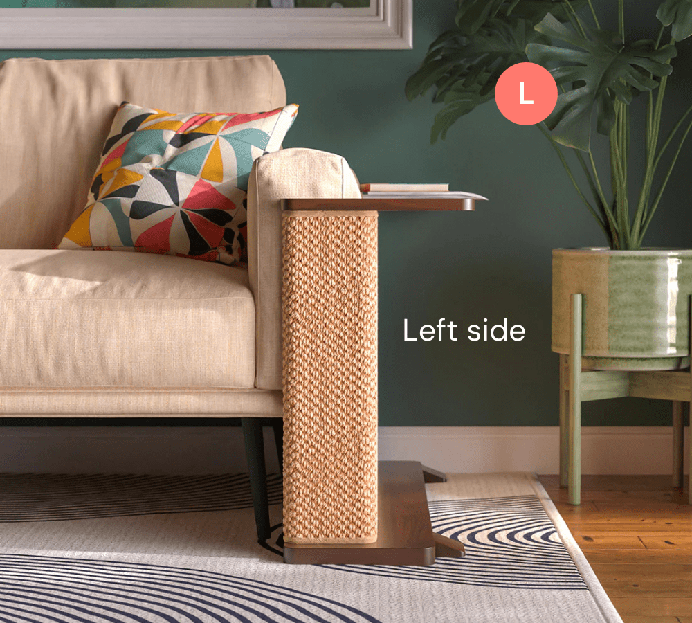 A Cat-e-Corner table placed next to a sofa, integrating a cat's scratching post with a small table, in a room with a plant and a colorful cushion.